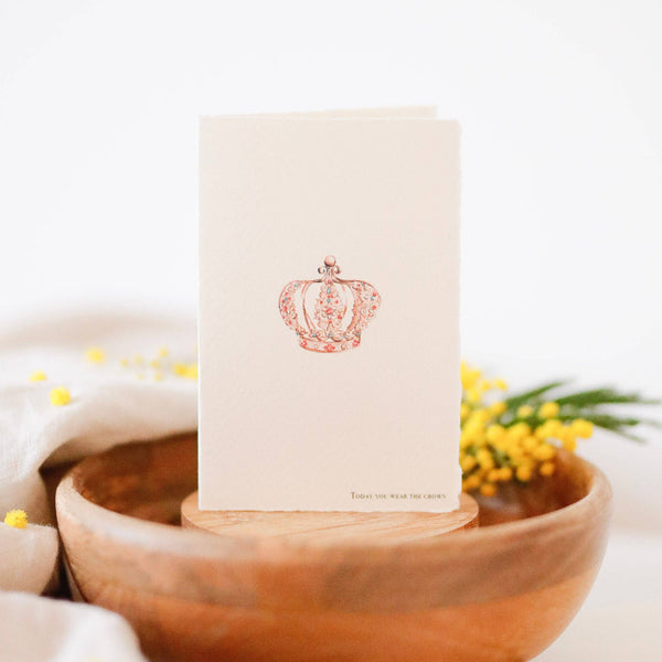 Wooden bowl with a white card featuring a red logo on a light background
