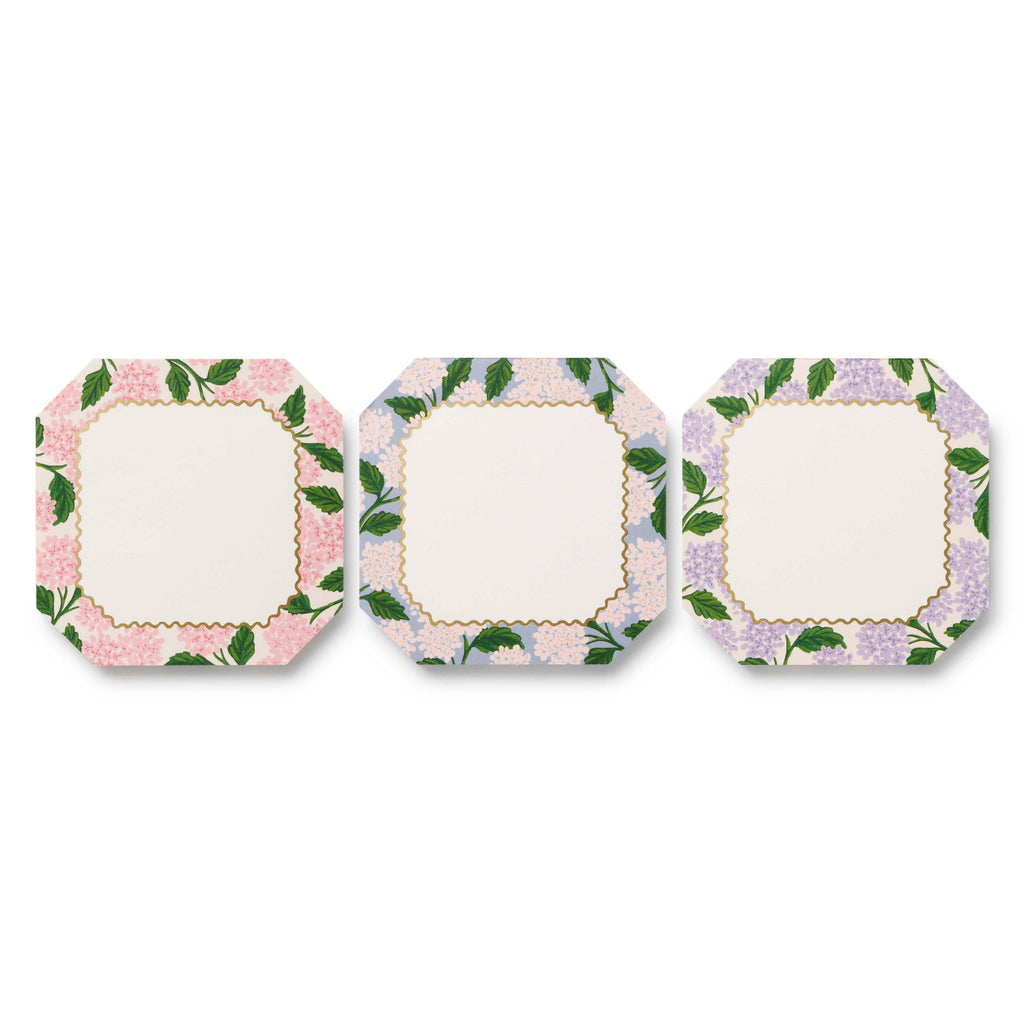 Set of three square plates with floral border design on a white background