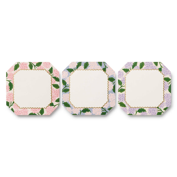 Set of three square plates with floral border design on a white background