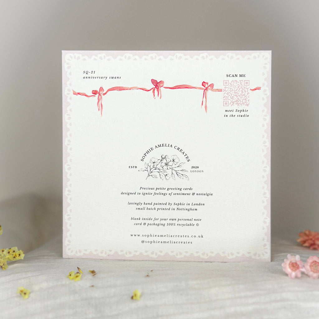 Greeting card with decorative ribbons and text on a light background