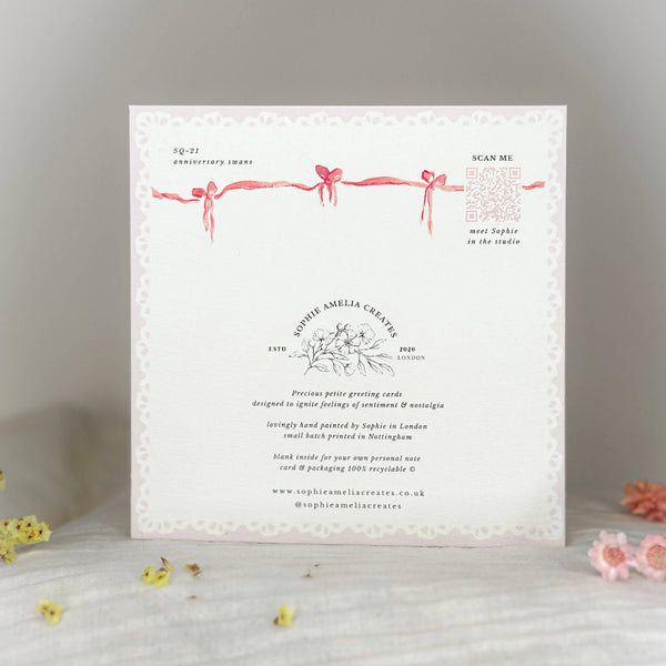 Greeting card with decorative ribbons and text on a light background