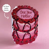 Card with lace design and 'One Year Hotter' text on a pink background