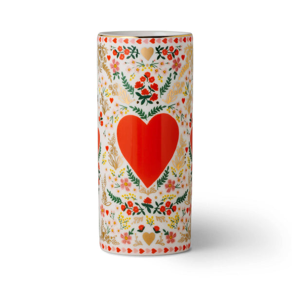 Decorative cylindrical container with a red heart and floral patterns on a white background