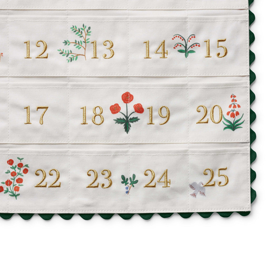 Advent calendar with embroidered numbers and festive designs on a white background