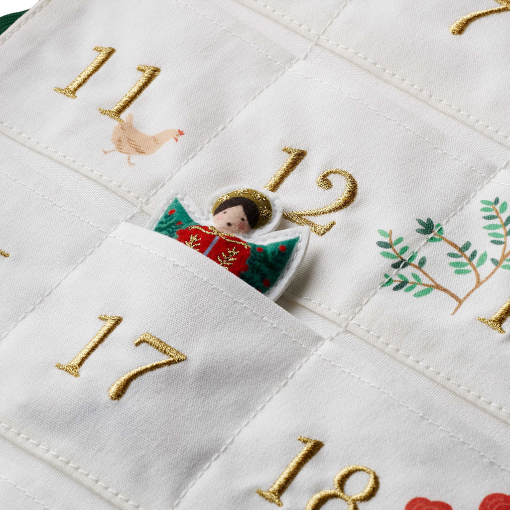Embroidered advent calendar with numbers and festive designs on a white background