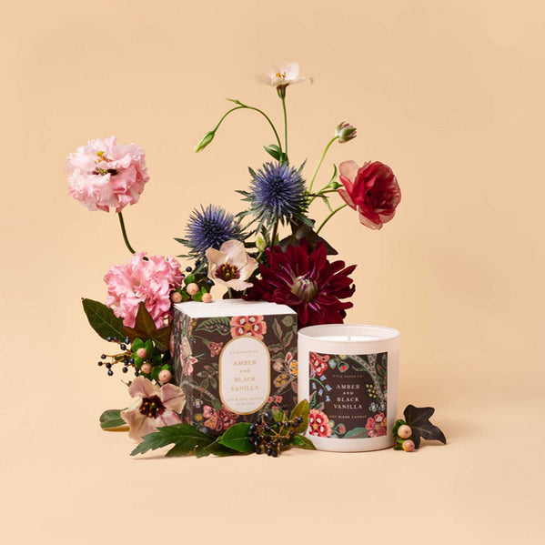 Two candles with floral designs on a beige background