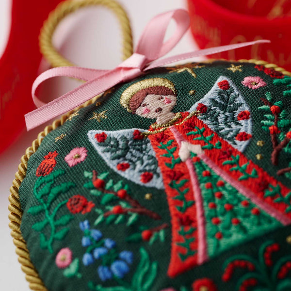 Embroidered heart-shaped ornament with a pink ribbon on a white background