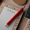 Red pen with Christmas design on a decorated card
