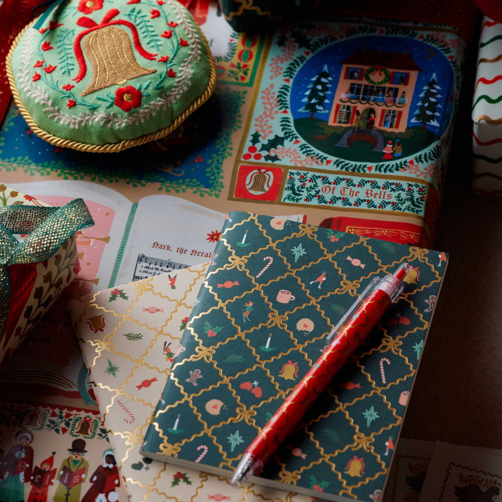 Decorative stationery items including a notebook, pen, and gift box on a colorful surface.