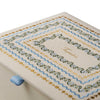 Cross-stitched fabric with decorative patterns on a white background