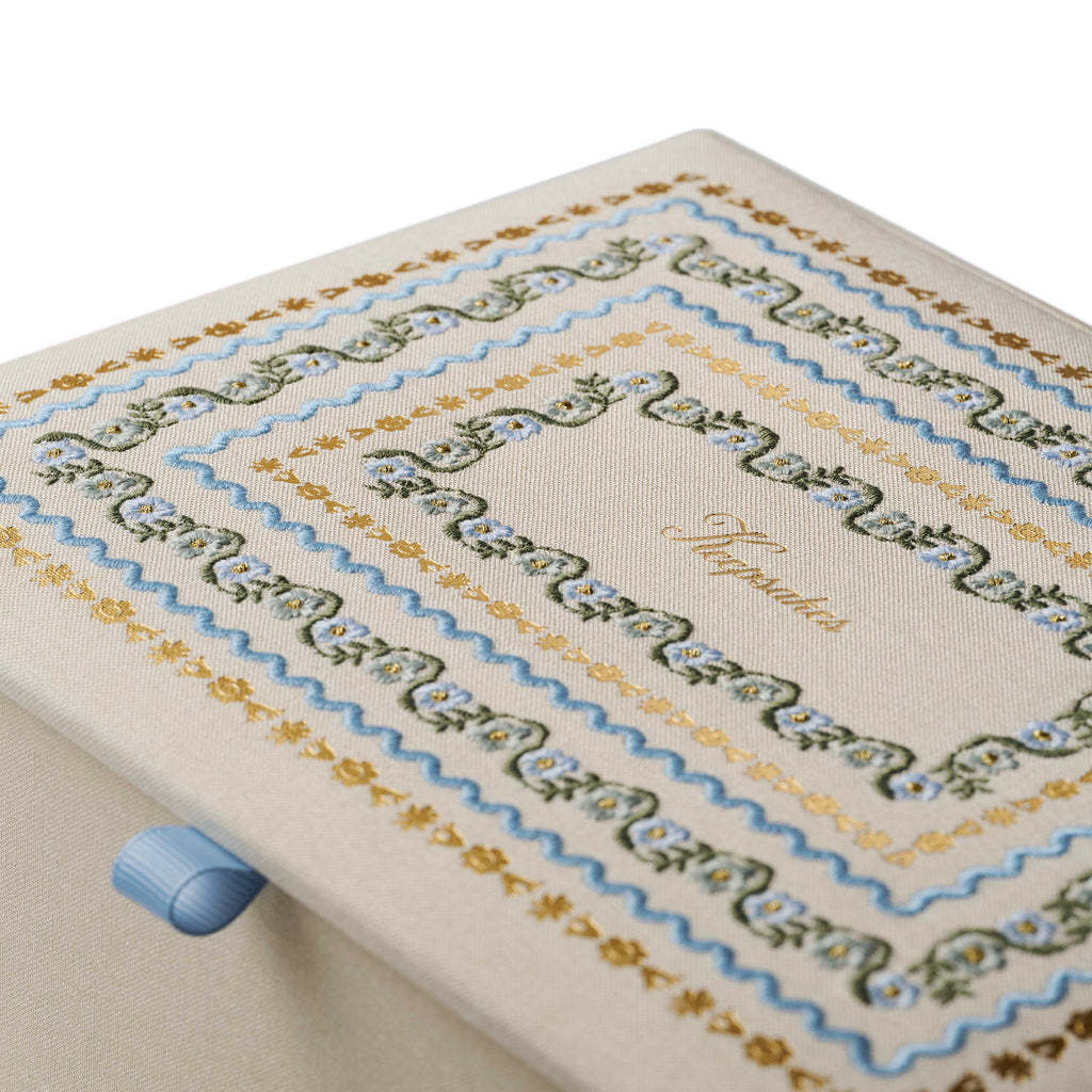 Cross-stitched fabric with decorative patterns on a white background