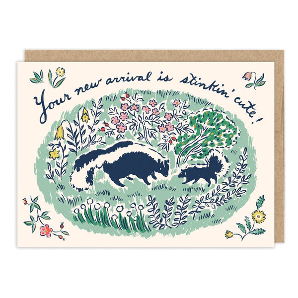 Greeting card with skunk illustration and floral design, featuring text 'Your new arrival is stinkin' cute!'.