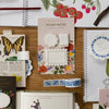 Floral sticky notes and decorative items on a wooden surface with stationery items.