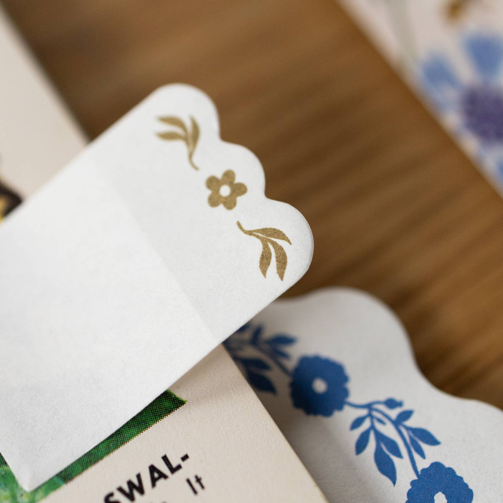 Close-up of a decorative card with floral designs on a wooden surface.