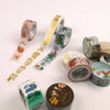 Set of decorative washi tape rolls with floral and nature-themed designs on a white background.
