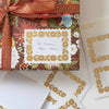 Gift wrapped with floral pattern and ribbon, featuring a personalized card.