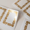 White cards with gold floral patterns on a beige background