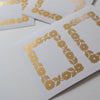 White cards with gold floral patterns on a light gray background