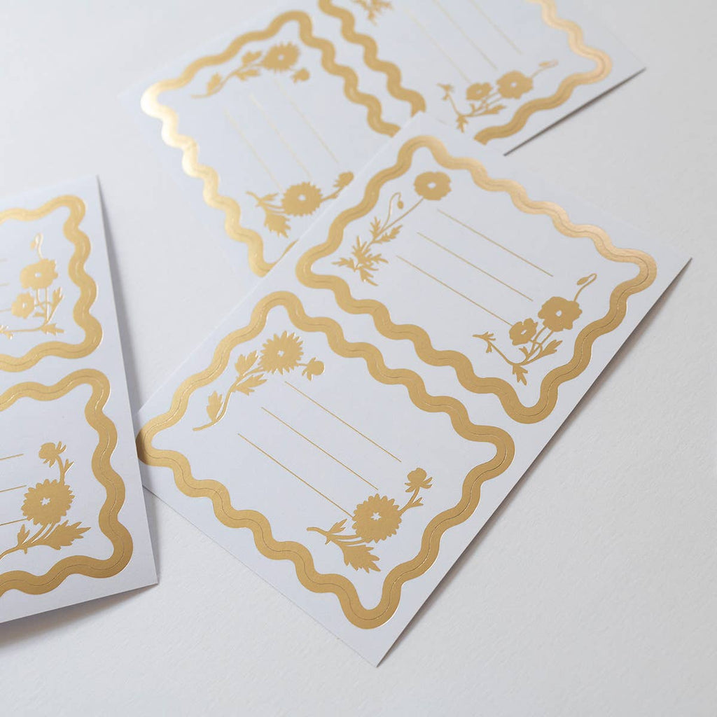Two white cards with gold decorative borders and floral elements on a light gray background.