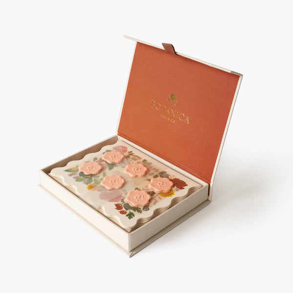 Open box of floral soap bars with 'Botanica' branding on a white background