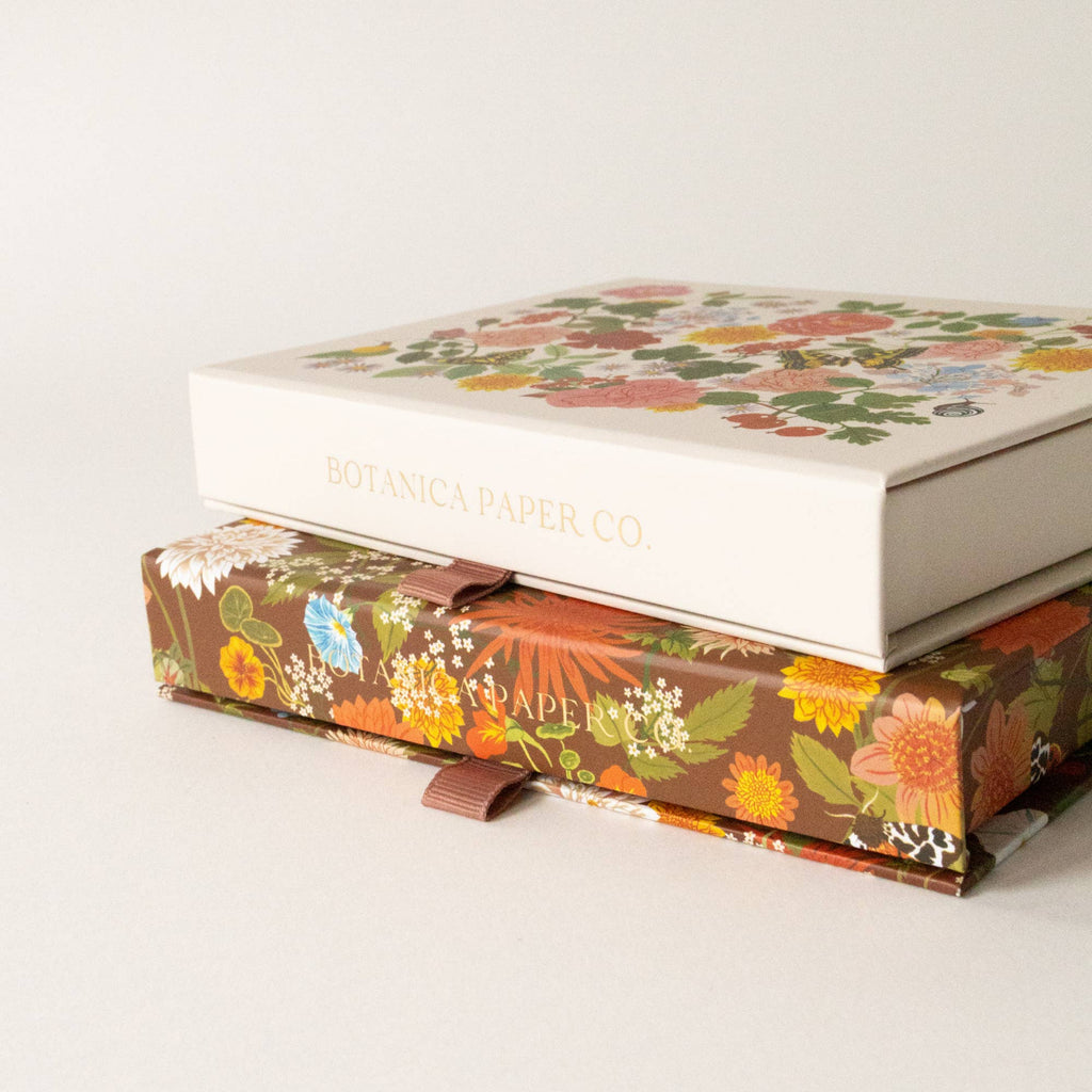 Two floral-patterned boxes stacked on a white background