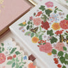 Floral and butterfly design on a notebook cover with matching stickers.