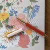 Floral notebook with a red pen on top