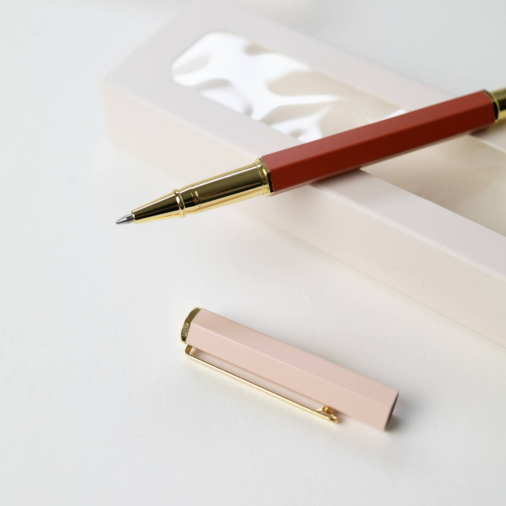 Red pen with gold accents on a white surface