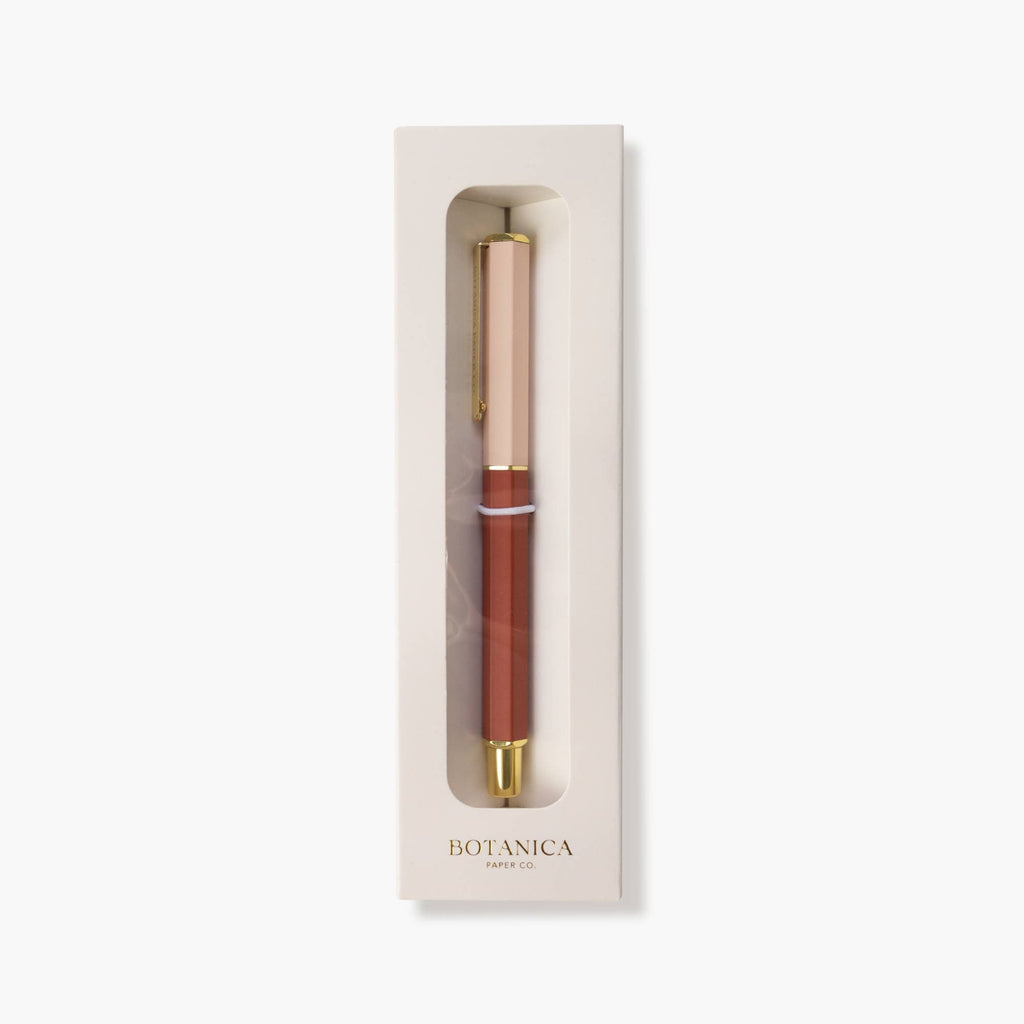 A Botanica pen with a rose gold cap and a terracotta brown barrel, presented inside its cream-colored packaging box against a light gray background.