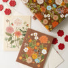 Floral-patterned notebooks and envelopes on a white background