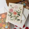 Floral card with matching envelopes on a white surface