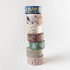 Stack of colorful washi tape rolls with floral patterns on a white background