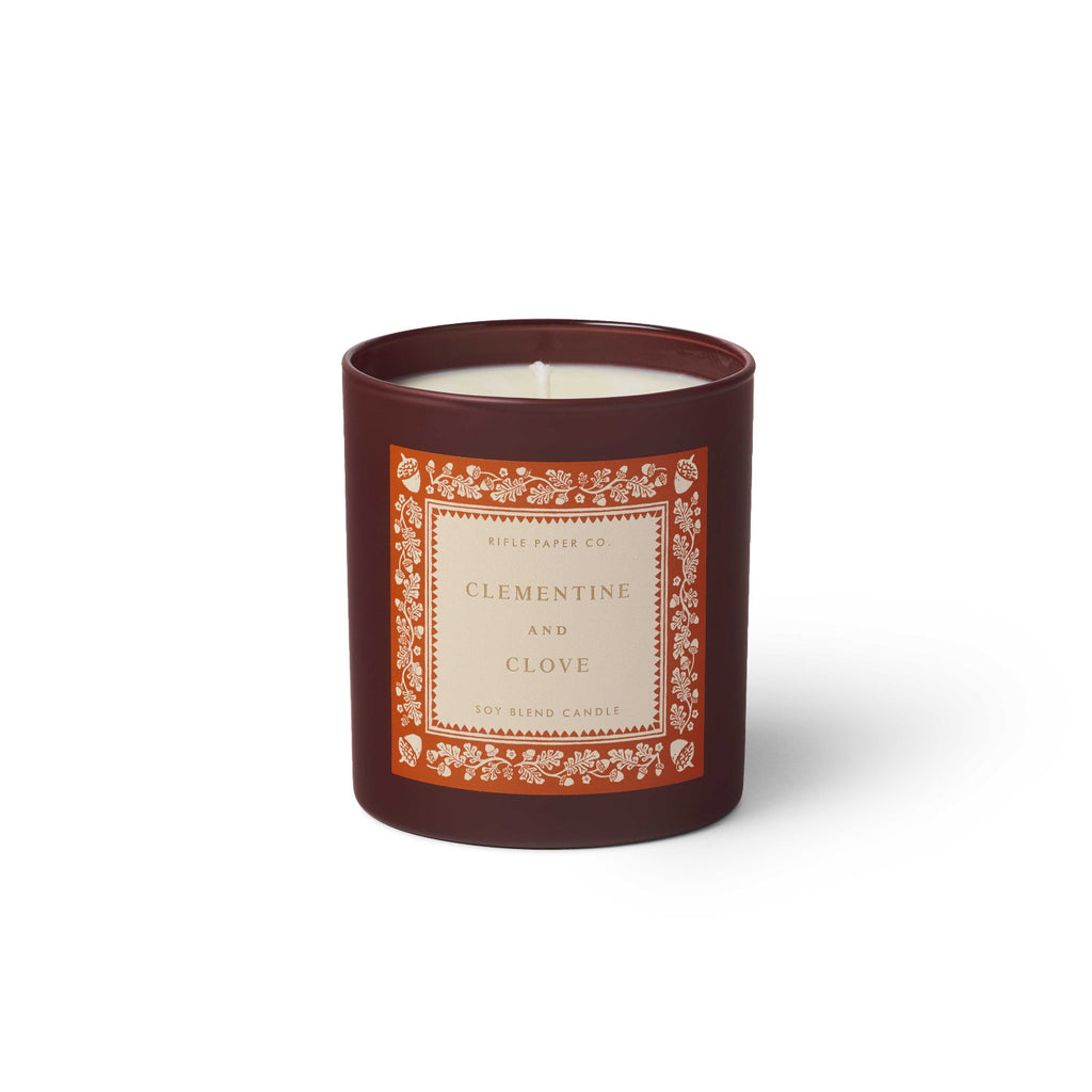 Candle in a decorative container with a label on a white background