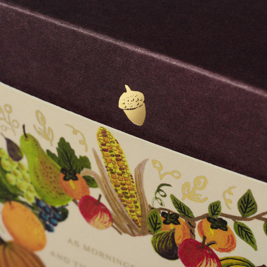 Close-up of a decorative box with fruit illustration and gold acorn detail