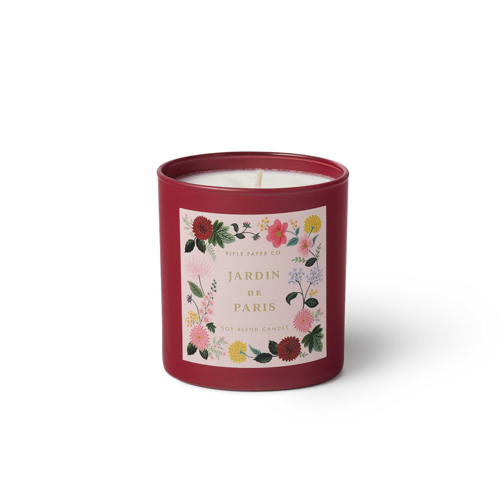 Candle in a red tin with floral design and 'Jardin de Paris' text on a white background