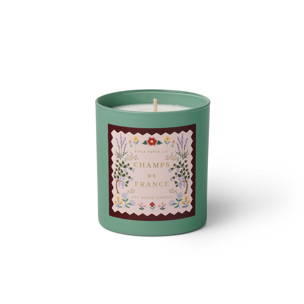 Green candle with floral design and text on a white background