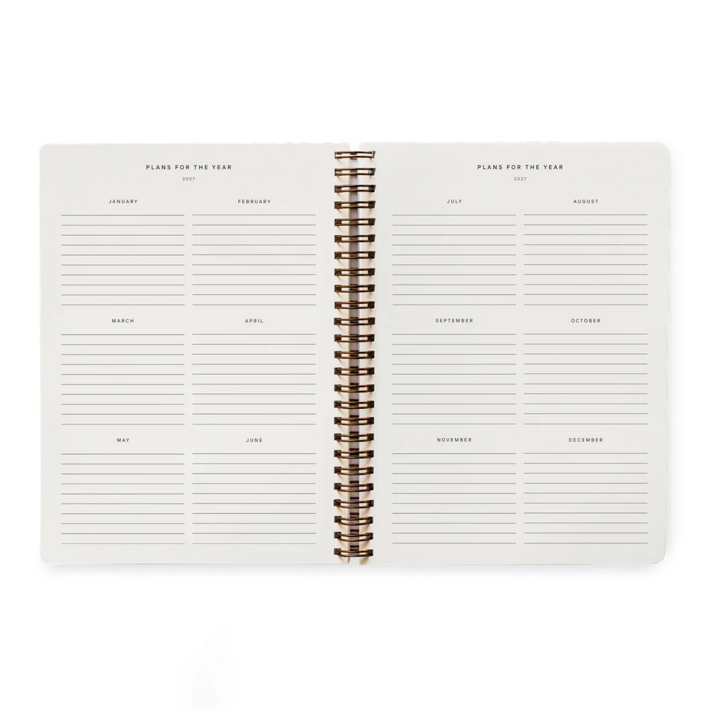 An open spiral-bound planner showing two weekly planning spreads for the year, with cream-colored pages and metallic gold rings on a white background.