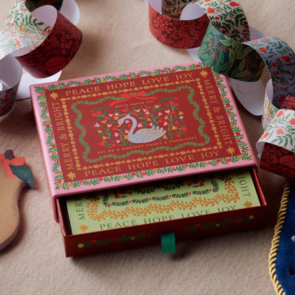 Decorative Christmas box with festive design on a table with holiday decorations.
