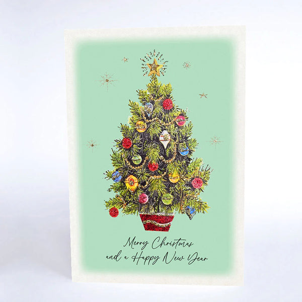 Christmas card with a decorated Christmas tree on a light green background