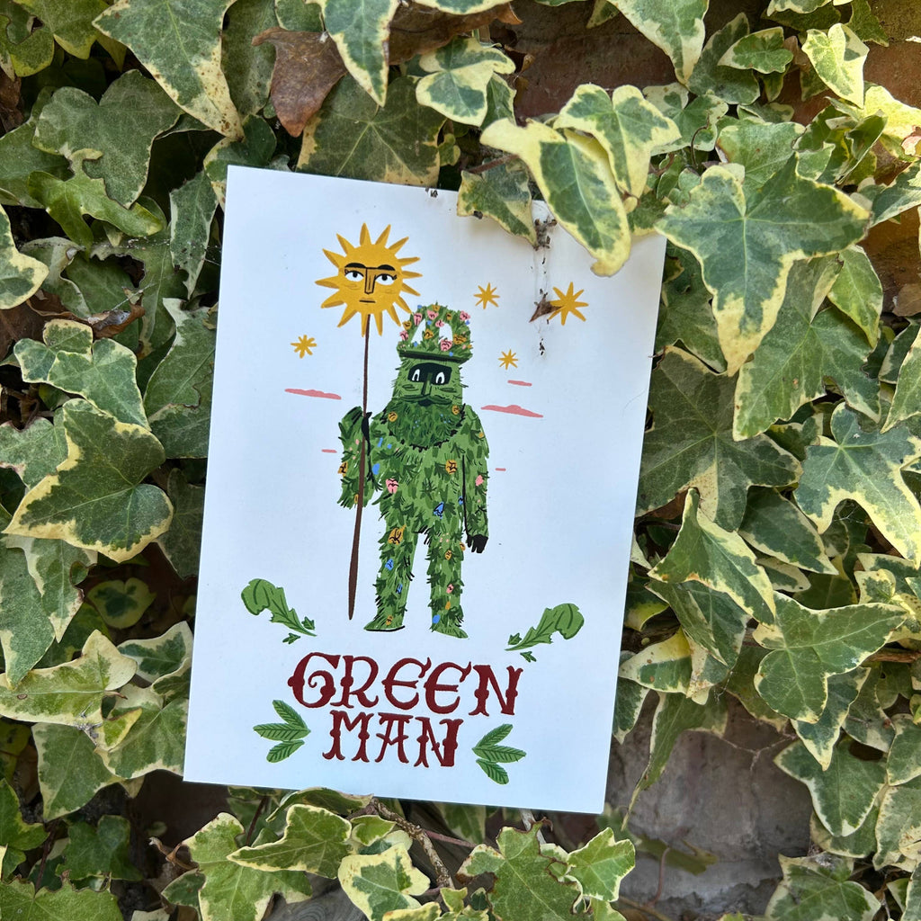Card with a illustration of a 'Green Man' surrounded by leaves on a leafy background