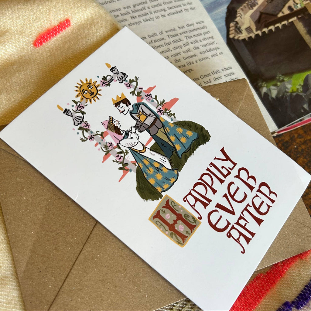 Card with 'Happily Ever After' text and illustrations on a textured surface with a castle image.