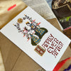 Card with 'Happily Ever After' text and illustrations on a textured surface with a castle image.