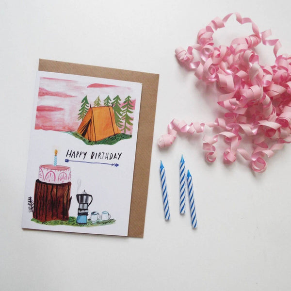 Birthday card with camping illustration, candles, and pink confetti on a white background