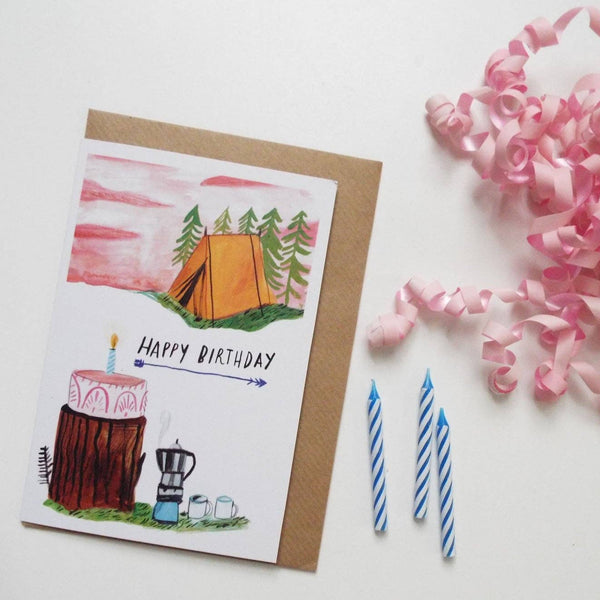 Birthday card with camping illustration, candles, and ribbons on a white background