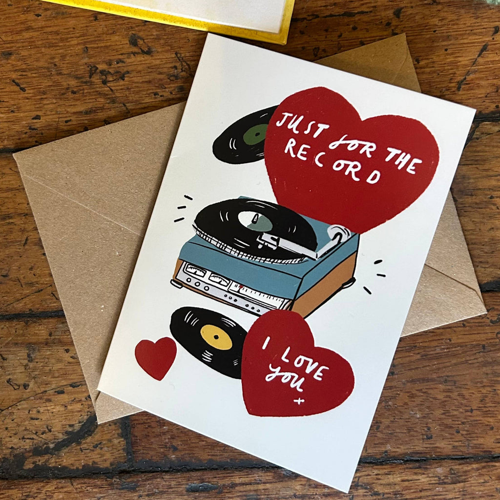 Greeting card with record design and hearts on a wooden surface