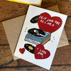 Greeting card with record design and hearts on a wooden surface