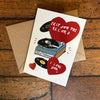 Greeting card with record player and hearts on a wooden surface