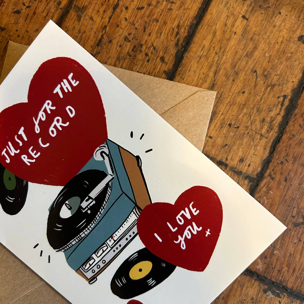 Greeting card with a record player and hearts on a wooden surface