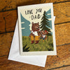 Greeting card with two bears and 'Love You Dad' text on a wooden surface