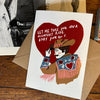 Card with cowboy illustration and heart-shaped text on a wooden surface